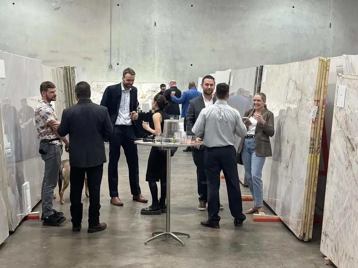 Guests talking around a cocktail table between stone slabs at a Capitol Keys evening